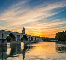 Warm evening light over a historic stone bridge in Provence